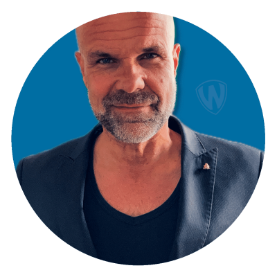 Junger, attraktiver Mann vor einem blauen Hintergrund.